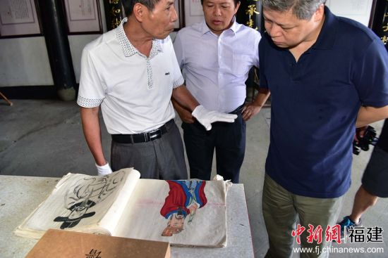 近日，村中长老蔡维华（左1）为中新社福建分社社长徐德金（右1）展示了桂峰村蔡氏百年族谱。