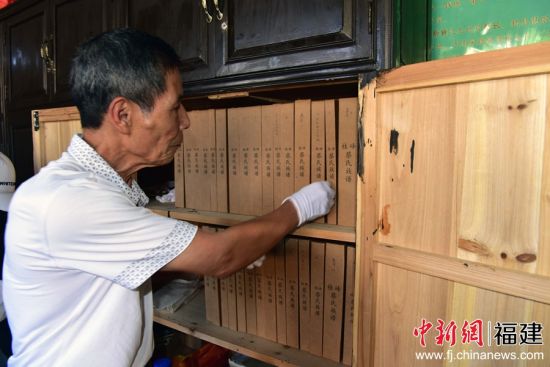 近日，村中长老蔡维华为记者取桂峰村蔡氏百年族谱。